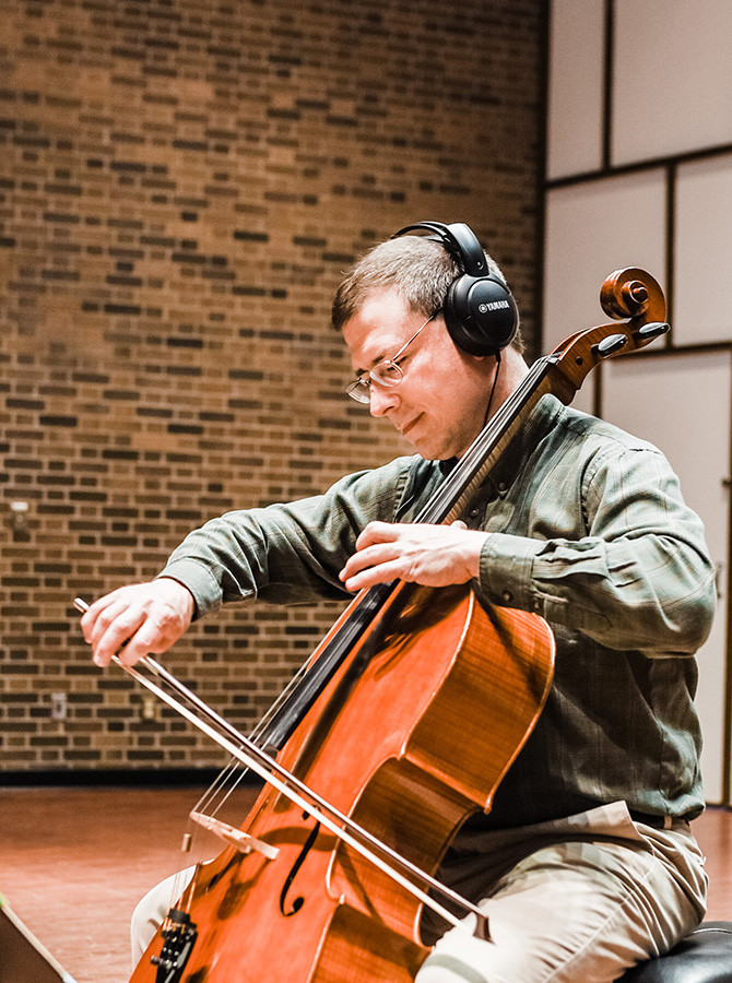 Benjamin Whitcomb playing cello onstage